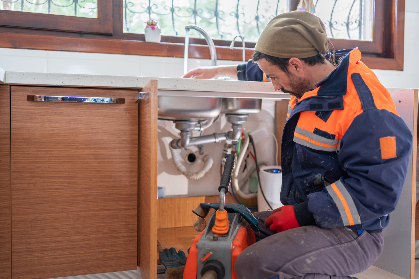 plumber unclogging sink drain cleaning